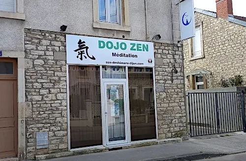 Intérieur du dojo zen de Dijon avec tatamis et coussins de méditation, ambiance paisible.