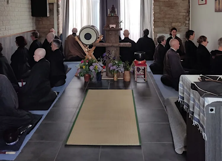 Pratiquant de zazen en Bourgogne assis sur un coussin de méditation dans le dojo zen.